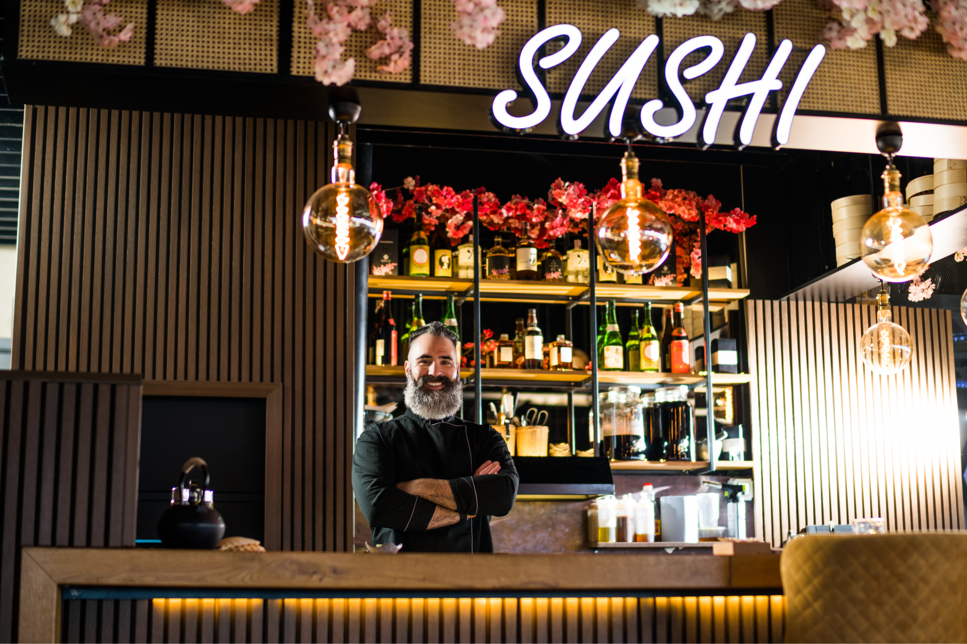 Szef kuchni w restauracji sushi stojący za ladą