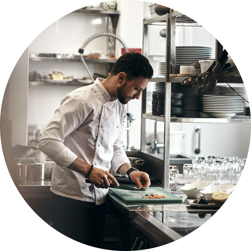 zarzadzanie-kosztami-kuchnia-posbistro Kucharz w profesjonalnej kuchni restauracyjnej przygotowujący danie, korzystający z optymalizacji magazynowej w systemie POSbistro.